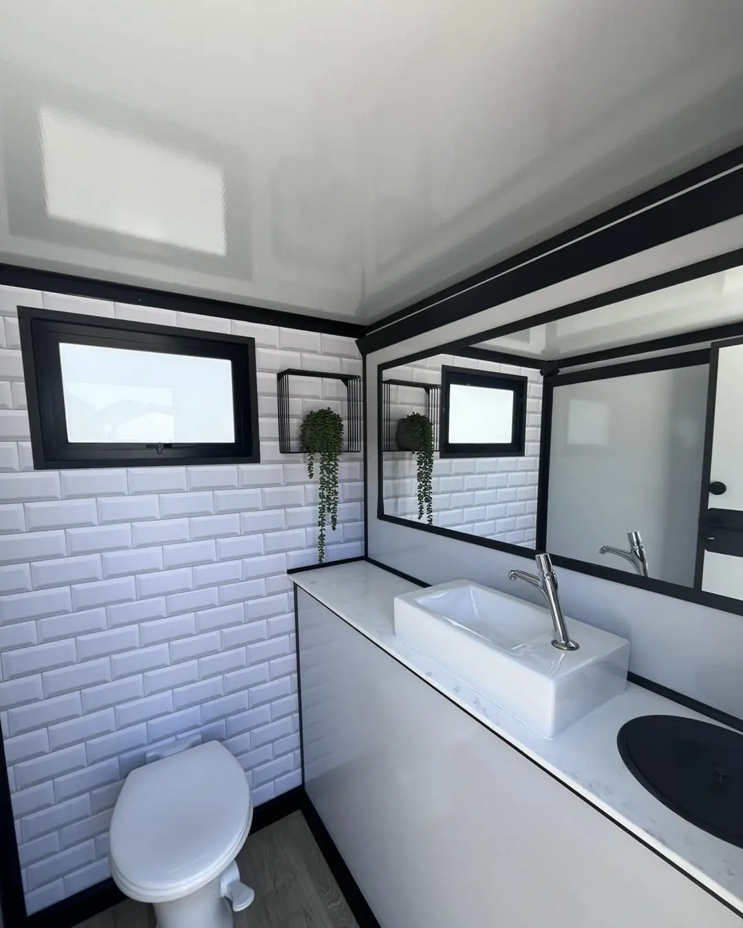 Tiled stall inside a luxury restroom trailer with toilet and vanity