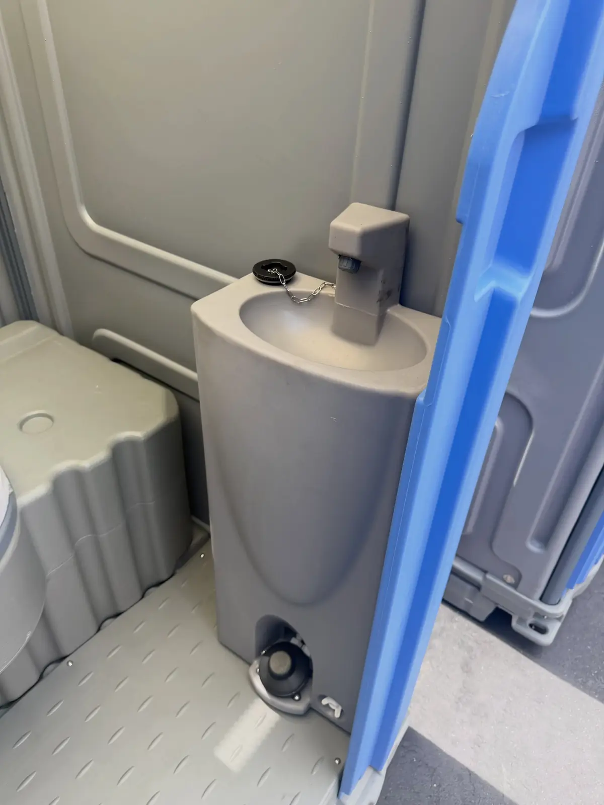 Foot-pump sink inside a deluxe unit, filled from its own tank