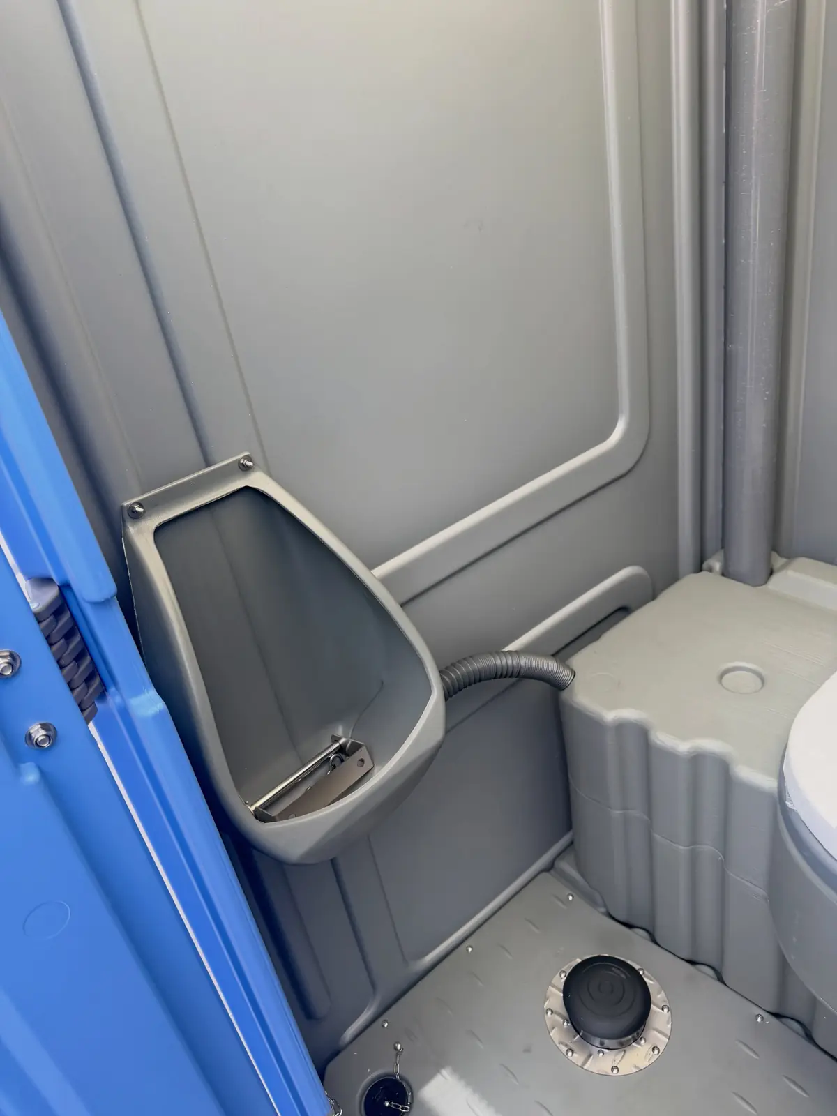 Inside a standard unit with a urinal, toilet seat and paper holders, ready for a shift crew